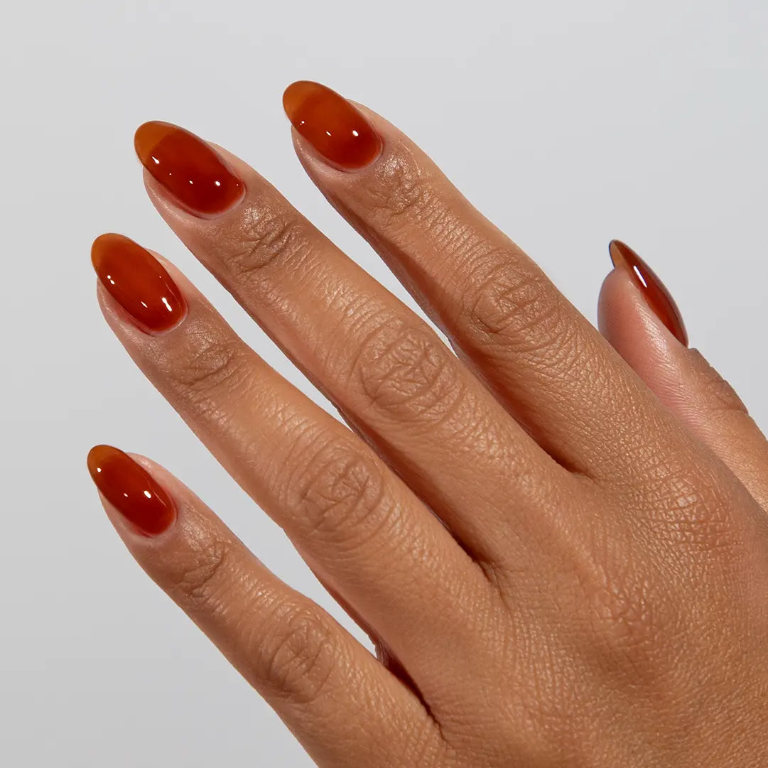 DND DC jelly gel polish on a manicured hand for Caramel 034 showing the warm luminous glow in natural light