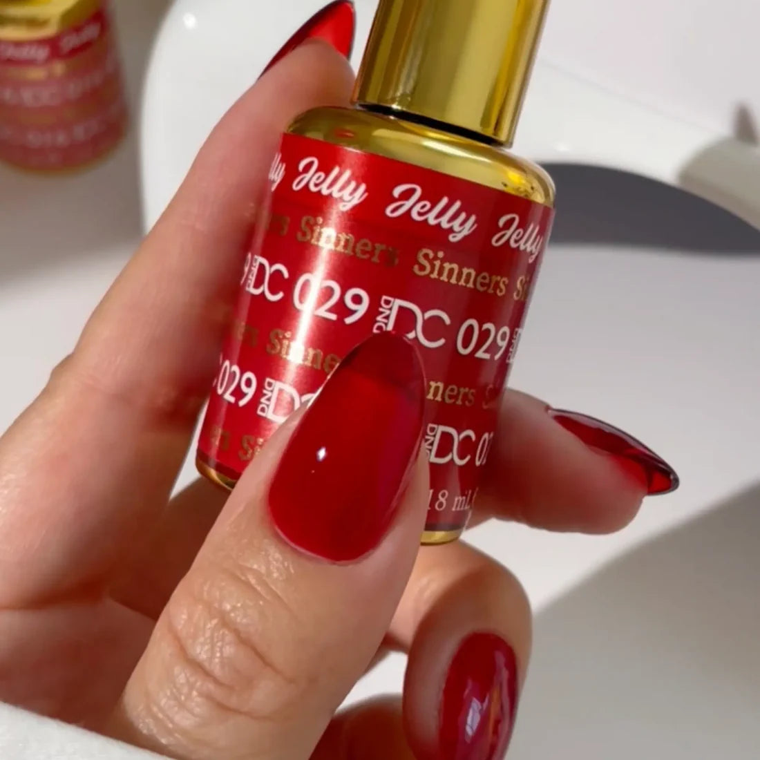 DND DC jelly gel polish bottle for Sinner 029 in a ruby red finish with orange undertones
