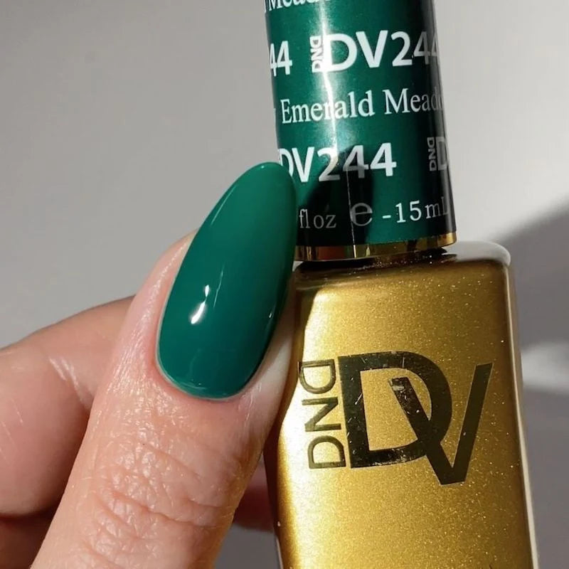Fingers manicured in DND DIVA 244 Emerald Meadow deep forest green gel polish shade