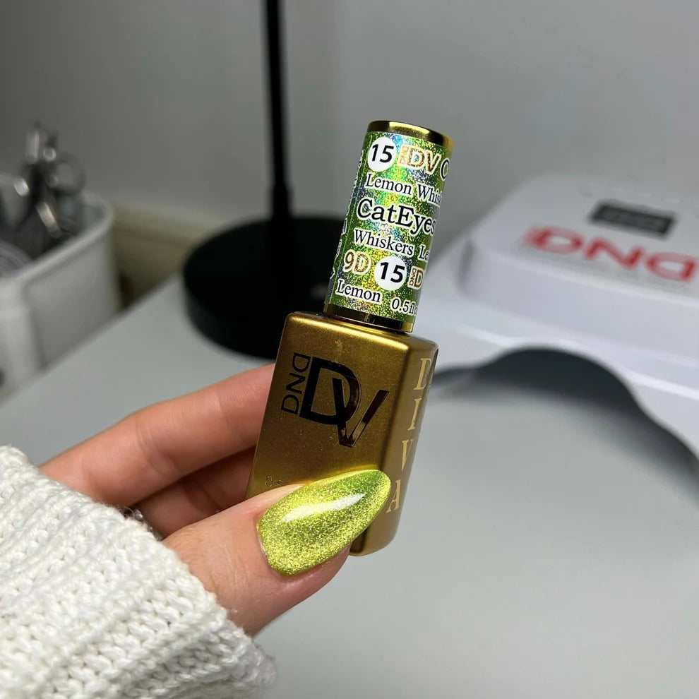 Hand with a lemon lime cat eye manicure holding the DND Diva Cat Eye Gel Polish #15 Lemon Whiskers bottle.