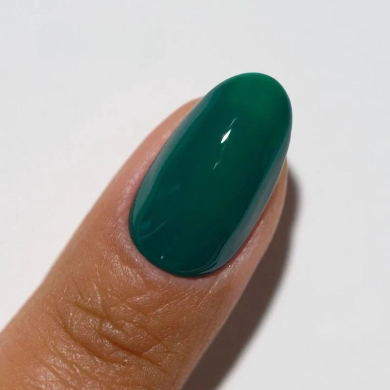Manicured nails painted with DND DIVA Emerald Meadow deep forest green gel polish