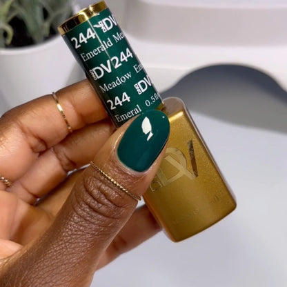 Hand showing finished manicure in DND DIVA Emerald Meadow deep forest green gel nail polish