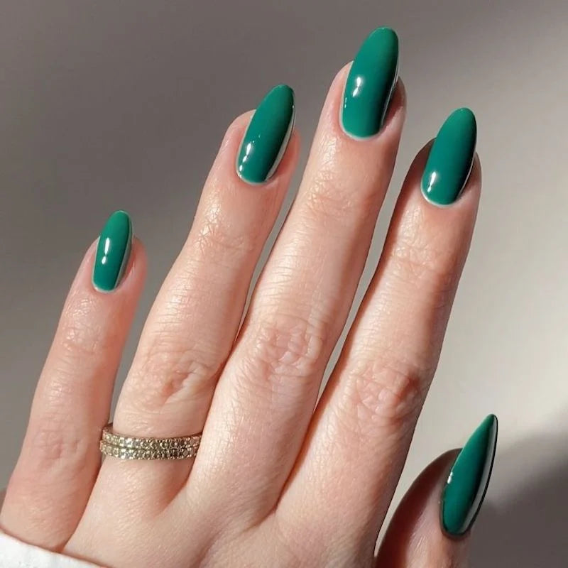Close up of manicured hand with DND DIVA Emerald Meadow deep forest green gel nails