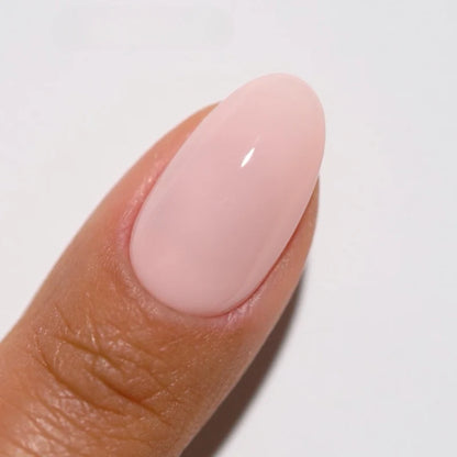 Hand showing finished manicure in DND DIVA Painter's Antidote light apricot pink beige gel nail polish