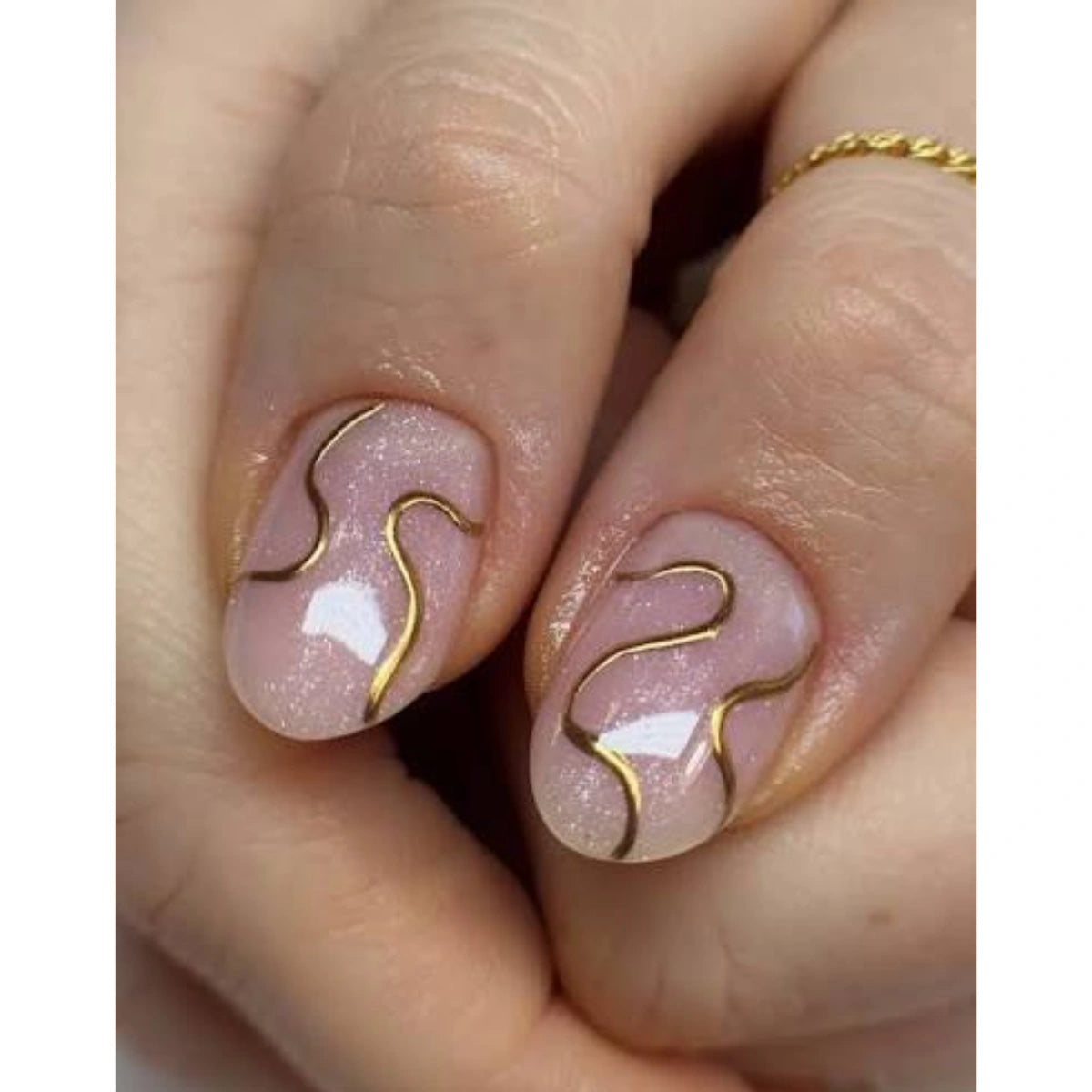 Thin light gold gel art liner lines painted over a colour base for nail art
