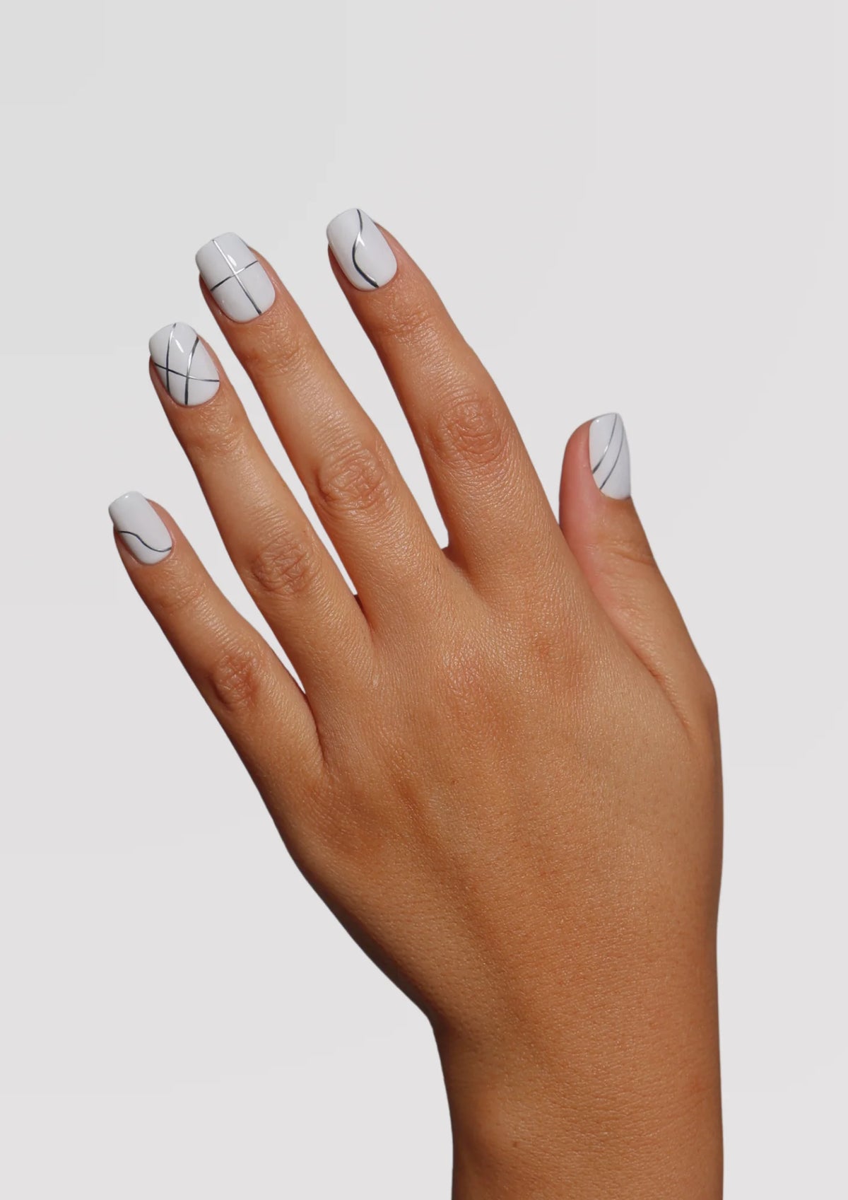 Thin silver gel art liner lines painted over a colour base for nail art
