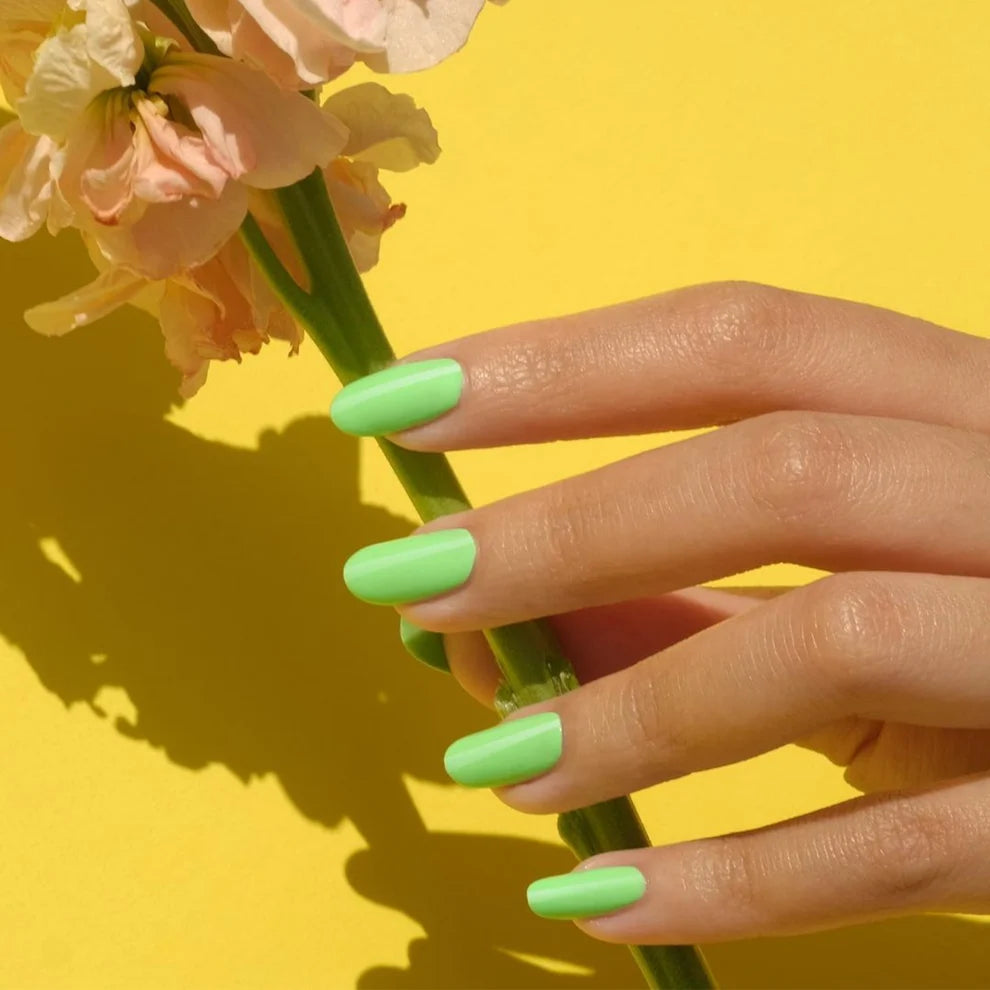 Close up manicure shot of DND Green Forest #568 on the nail, highlighting the bright neon finish and white undertone