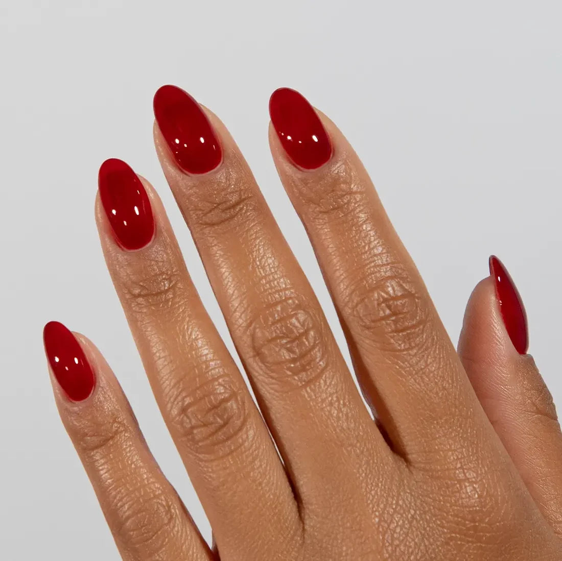 DND DC jelly gel polish on a manicured hand for Sinner 029 showing the ruby red glow in natural light