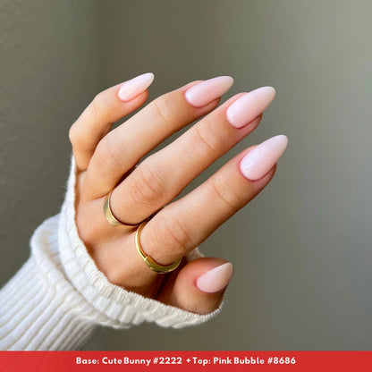 Side angle manicured hand wearing DND Pink Bubble #8686 sheer porcelain pink nail polish