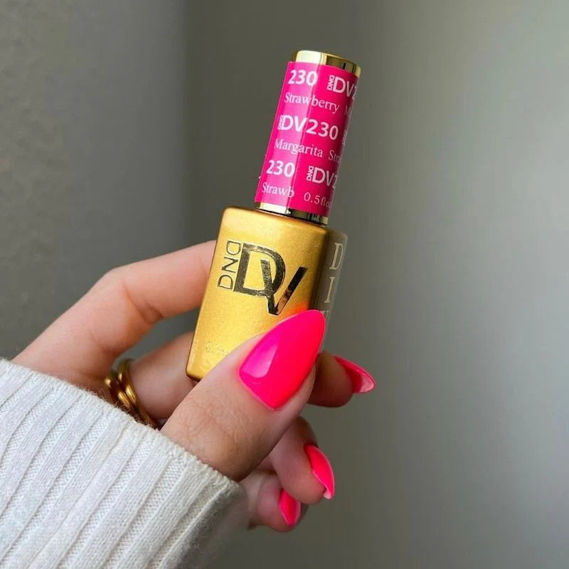 Manicured hand wearing DND pink nail polish in Strawberry Martini shade