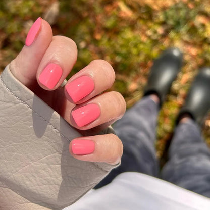 Manicured hand wearing DND Princess Pink #538 gel polish, showing the bubblegum pink shade with peach undertones on the nail