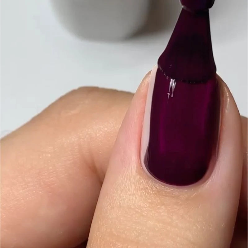 Rosewood manicure featuring DND Rosewood #428 while holding the matching Gel & Lacquer Duo.