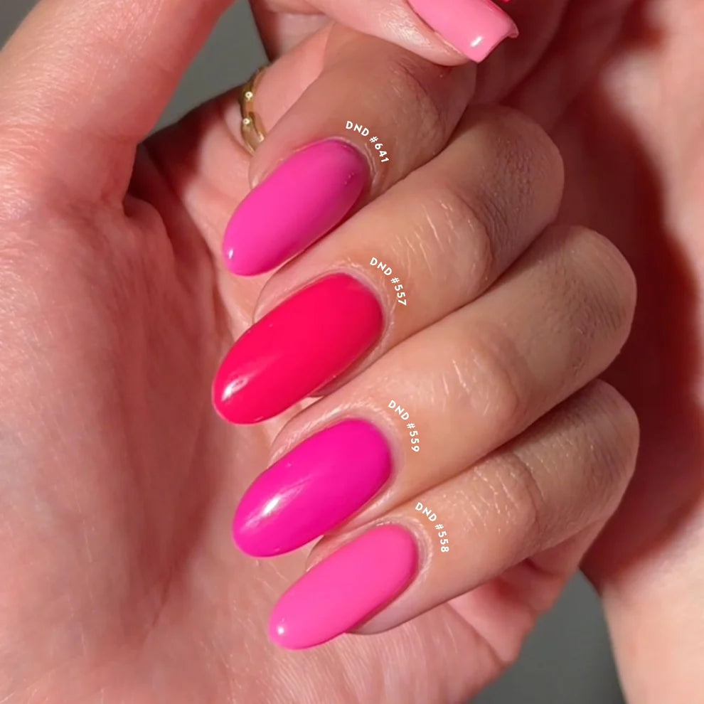 Hand wearing DND Teenage Dream #559 gel polish, showing the bold neon pink tone on the nails