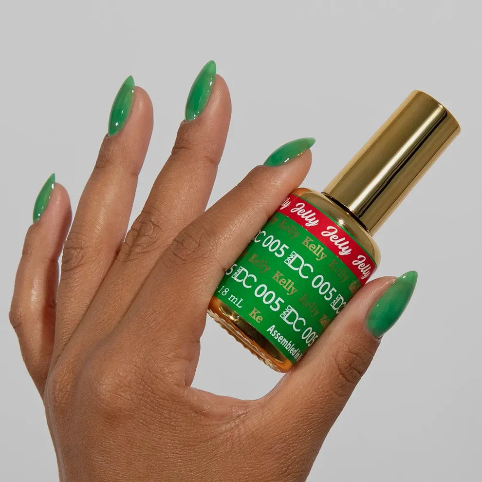 Close view of a manicured hand showing the emerald green jelly nail polish finish of DC Jelly 05 Kelly