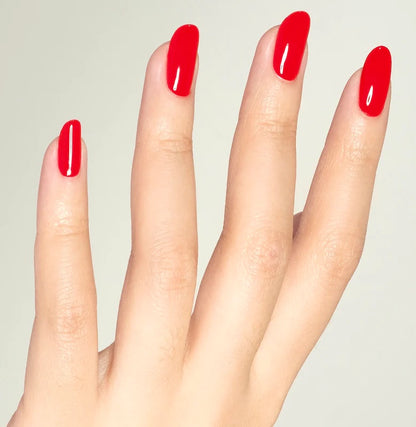 Professional manicure with DND Ferrari Red nail polish showing bright racing red glossy finish on female hands