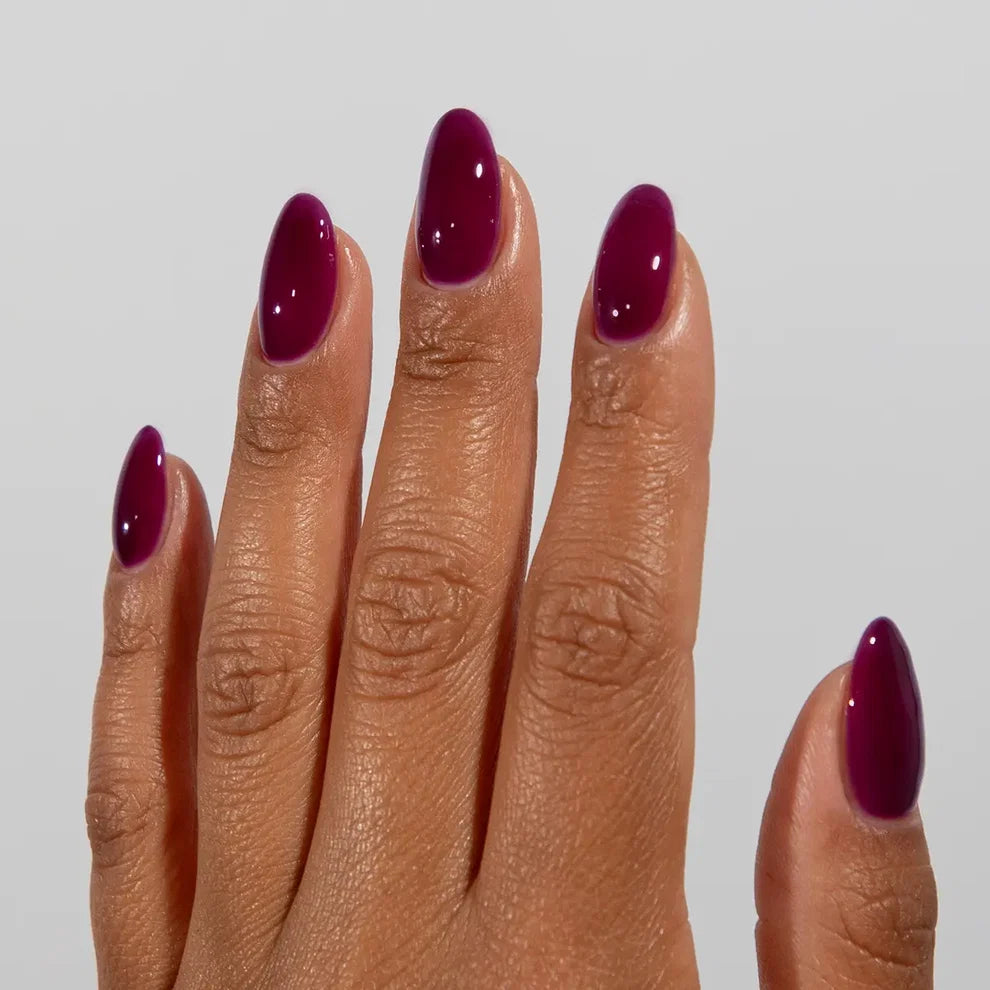 Manicured hand wearing DC Jelly 020 Grape jelly gel polish to show the juicy saturated purple finish in natural light