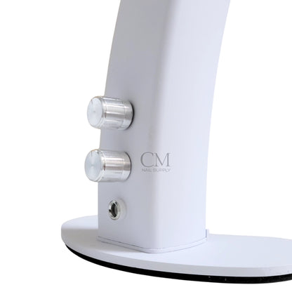 Half moon nail desk lamp providing LED lighting across a manicure workspace