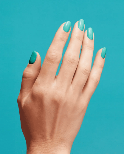 Hand with teal nail polish on a teal background