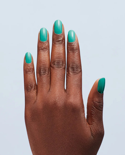 Hand with teal nail polish on a light blue background, OPI I’m Yacht Leaving