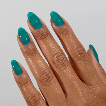Manicured hand wearing DC Jelly 024 Jade jelly gel polish to show the ocean inspired turquoise finish in natural light
