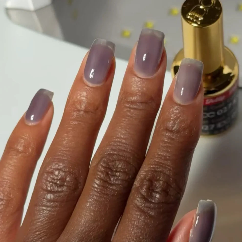 Manicured hand with DC Jelly 027 Coal jelly gel polish applied to show the finished salon style manicure