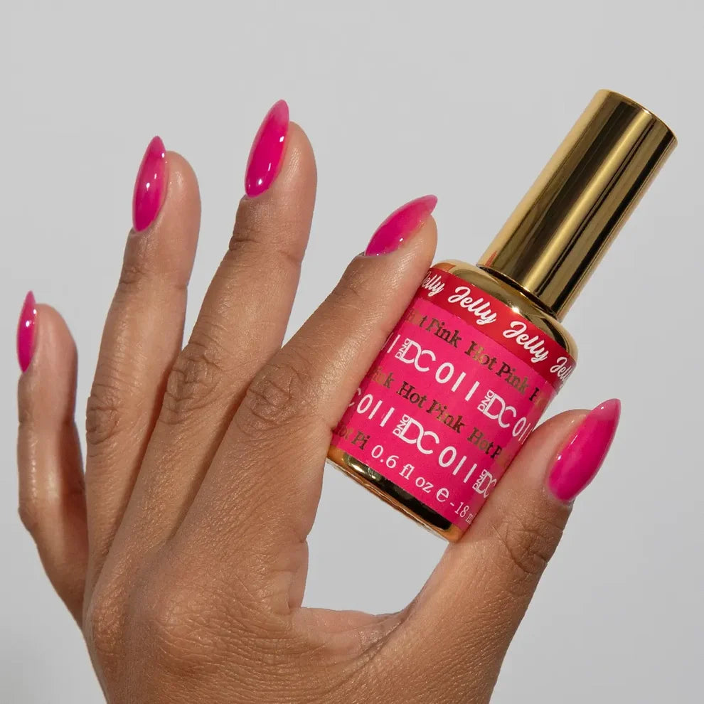 Manicured hand holding the DC Jelly 011 Hot Pink jelly nail polish bottle, showcasing the bold hot pink color on the nails