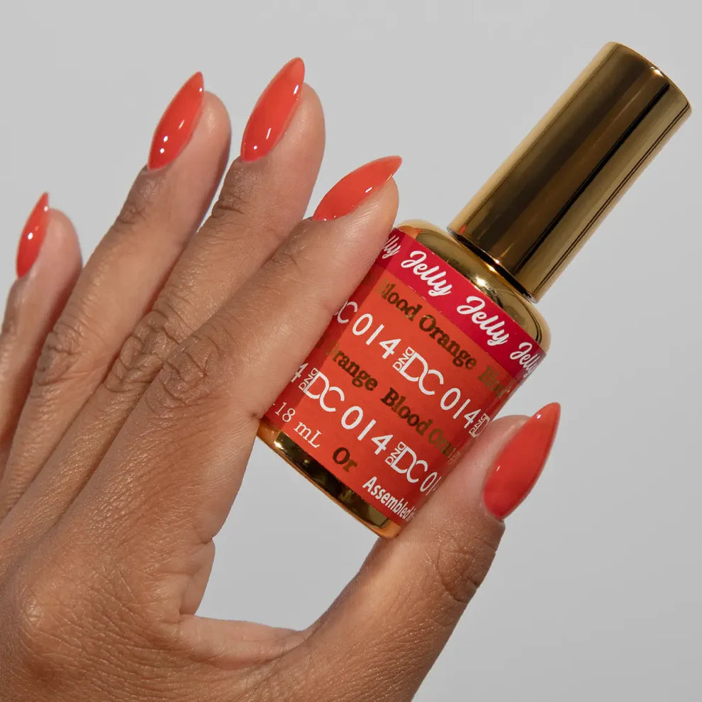 Manicured hand holding the DC Jelly 014 Blood Orange jelly nail polish bottle, showcasing the deep neon orange color on the nails