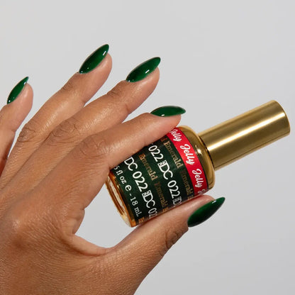 Manicured hand holding the DC Jelly 022 Emerald jelly nail polish bottle, showcasing the emerald green color on the nails