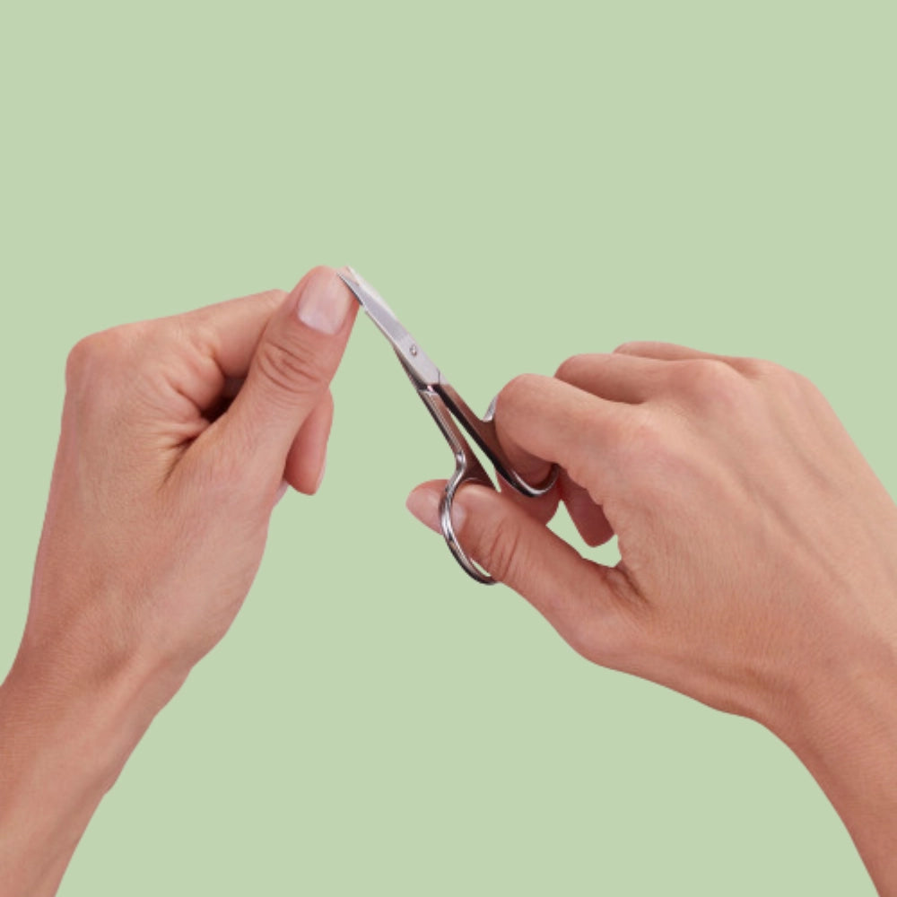 A selection of professional nail scissors including cuticle scissors and manicure scissors arranged on a clean white surface for salon use.