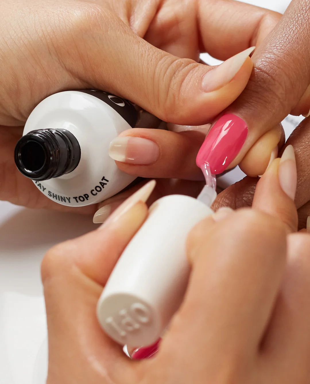 Professional nail technician applying OPI GelColor Top Coat to seal gel manicure color.