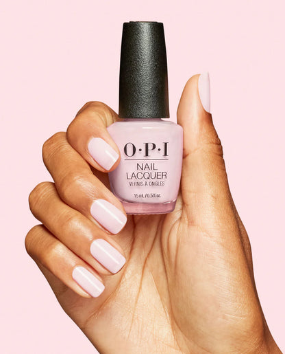 Hand holding a bottle of OPI nail polish with pink background, OPI Nail Lacquer I’m a Bubble Bunny S061 sheer light pink nail polish
