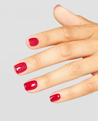 Hand with OPI red L72 red nail polish on a gray background