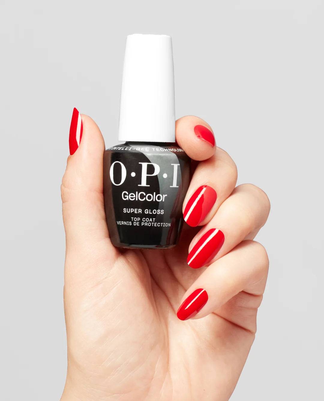 Hand holding Front label of OPI Super Gloss Top Coat showing product code GC 003 with red manicured hand