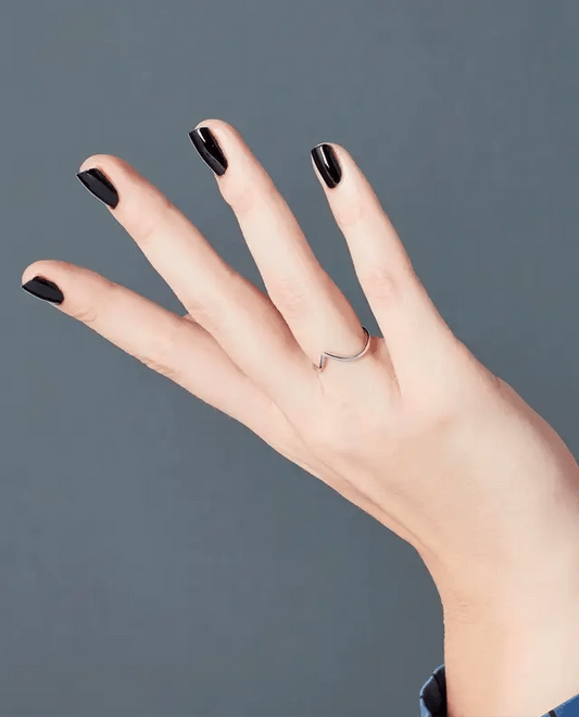 Manicured hand holding OPI T02 black gel polish bottle showing the glossy finish