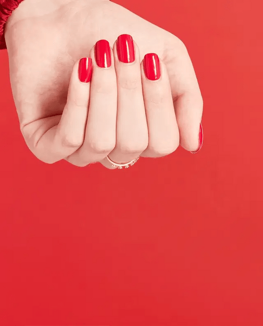 Manicured nails painted with OPI W62 red gel polish showing the bold commanding color