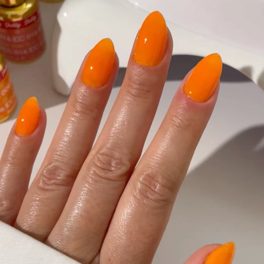 Manicured hand wearing DC Jelly 06 Orange jelly gel polish to show the creamy jelly finish in natural light