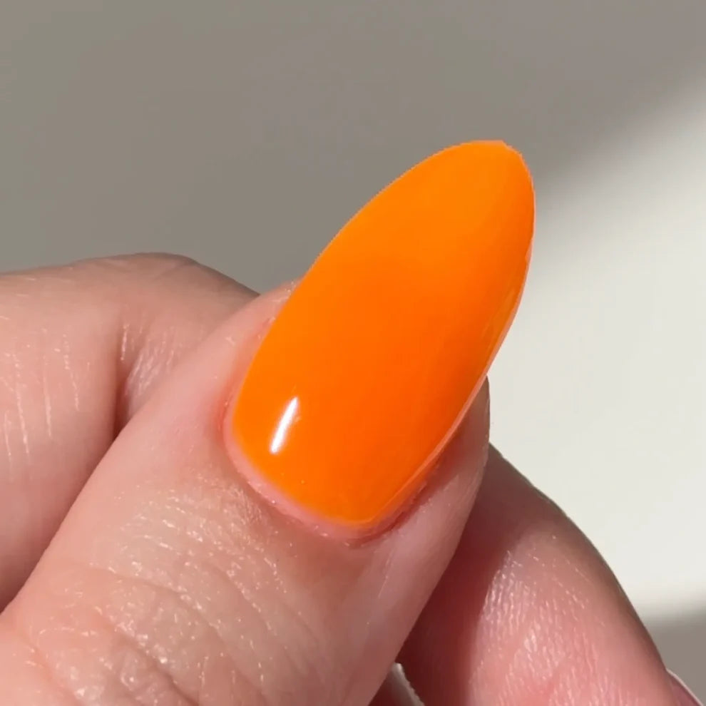Manicured nail wearing DC Jelly 06 Orange jelly gel polish to show the creamy jelly finish in natural light on pale skin
