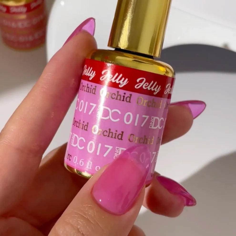 Manicured hand with light skin tone wearing DC Jelly 017 Orchid jelly gel polish in a pink purple finish