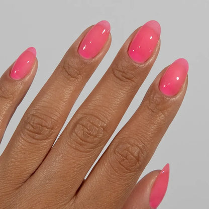Manicured hand wearing DC Jelly 010 Pink jelly gel polish to show the bright watermelon pink finish in natural light