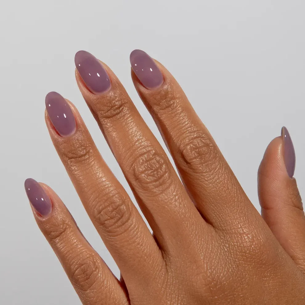 Manicured hand wearing DC Jelly 026 Plum Haze jelly gel polish to show the berry dreamy plum finish in natural light