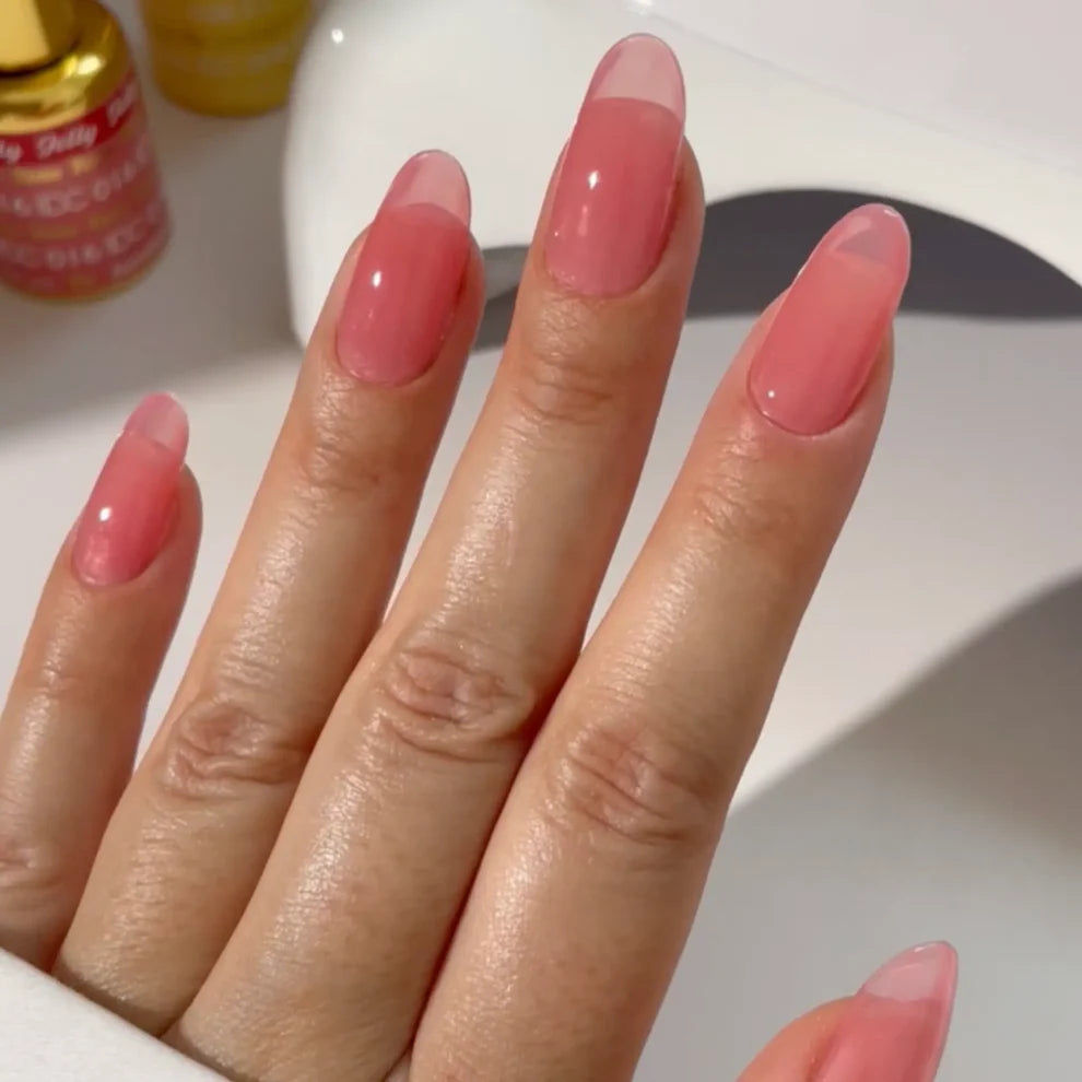 Manicured hand wearing DC Jelly 016 Rose jelly gel polish to show the dreamy pale pink floral finish in natural light