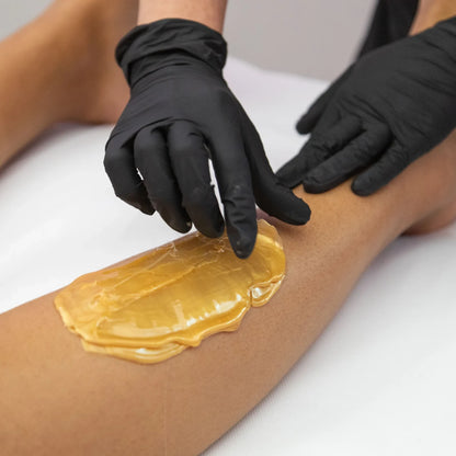 Technician applying Sharonelle hard wax to skin for professionals Canada