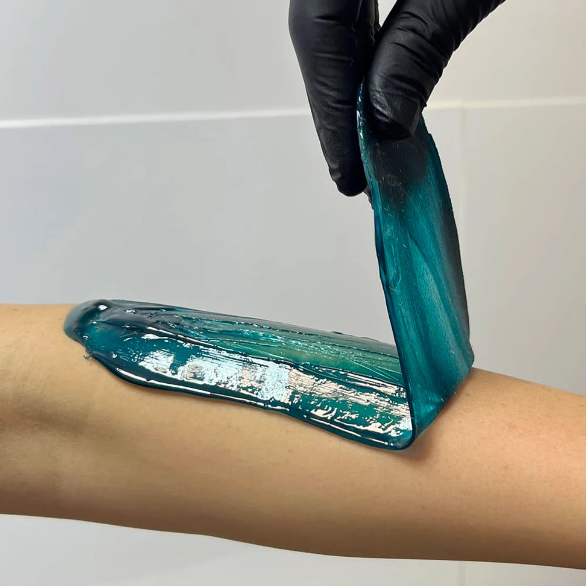 Technician applying Sharonelle azulene hard wax to skin
