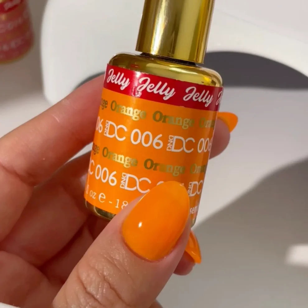 Hand holding a bottle of Jelly Orange nail polish with a white background